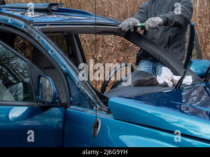 Arbeiter ersetzt eine Windschutzscheibe in einem Auto, das eine kaputte hatte Stockfoto