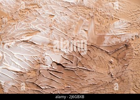Cremefarbene Textur auf einem pastellbeigen Hintergrund. Kosmetische Maske Balsam Gel. Abstriche des Fundaments für das Gesicht Stockfoto