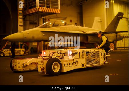 220423-N-EE352-1017 PACIFIC OCEAN (23. April 2022) der aus Conway, Ark., stammende Flugflieger Charles Phillips, Mate (Handling), manövriert einen Speckwagen in der Hangarbucht des Nimitz-Klasse-Flugzeugträgers USS Carl Vinson (CVN 70), April 23. Vinson führt derzeit routinemäßige Seeoperationen im Pazifischen Ozean durch. (USA Navy Foto von Mass Communication Specialist Seaman Leon Vonguyen) Stockfoto