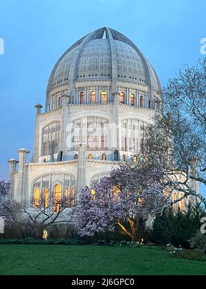 Baha'i House of Worship an einem frühen Frühlingsabend mit blühenden Bäumen in voller Blüte. Der Tempel befindet sich in Wilmette, Illinois. Stockfoto