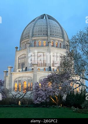 Baha'i House of Worship an einem frühen Frühlingsabend mit blühenden Bäumen in voller Blüte. Der Tempel befindet sich in Wilmette, Illinois. Stockfoto