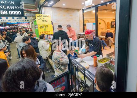 30. April, Lakemba, Sydney, Australien: In der letzten Nacht des Ramadan in Sydney ist das Ramadan Nights Festival von Sonnenuntergang um 17,30 Uhr bis zum 02,00. Am nächsten Morgen in vollem Gange. Hier erreicht eine Frau nach einer halben Stunde Wartezeit den vorderen Teil der Schlange auf einen traditionellen libanesischen Döner. Lange Menschenschlangen die Straße entlang, die darauf warten, dieses und andere Lebensmittel aus den vielen Nationen zu kaufen, die jeden Abend während des Festivals auf diesem Markt vertreten sind. Stockfoto