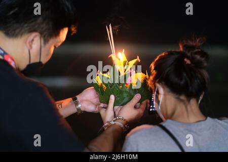 Krathong, ein dekorierter Korb mit Blumen und Kerze, ist bereit, an einer Nacht der Loy-Krathong-Feier in Thailand ins Meer zu entlassen Stockfoto