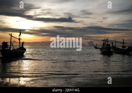 Ein Fischerboot, beleuchtet von untergehenden Sonnenstrahlen, bereit für eine nächtliche Abfahrt zum Andamanensee Stockfoto