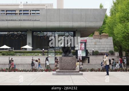 TOKIO, JAPAN - 17. April 2022: Skulptur im Garten des Tokioter Nationalmuseums für westliche Kunst mit Tokyo Bunka Kaikan im Hintergrund in Ueno Par Stockfoto