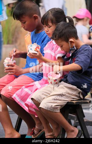 Phuket Thailand - November 21 2021: Kinder sind damit beschäftigt, auf einem Straßenmarkt buntes Eis zu essen Stockfoto