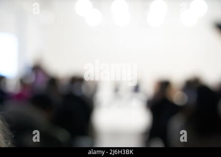 Verschwommener Hintergrund der Geschäftskonferenz, eine Gruppe von Menschen auf der Bühne, Präsentation des Projekts, öffentlicher Vortrag. Hochwertige Fotos Stockfoto