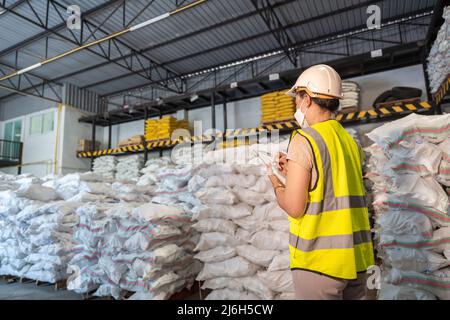 Eine Lagerarbeiterin nimmt zur Kenntnis, wie viele Chemikalien sich im Lager für Alaun oder Chemikalien befinden. Internationales Exportgeschäftskonzept. Stockfoto