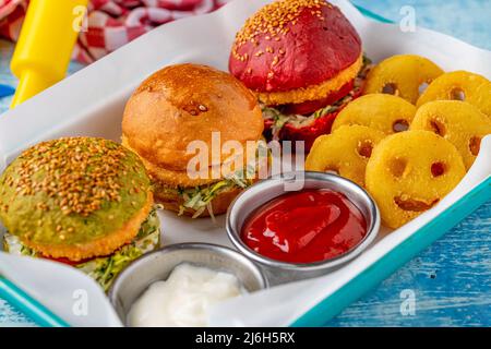 Drei Mini-Burger mit Huhn und Fleisch serviert mit pommes frites. Kindermenü Stockfoto