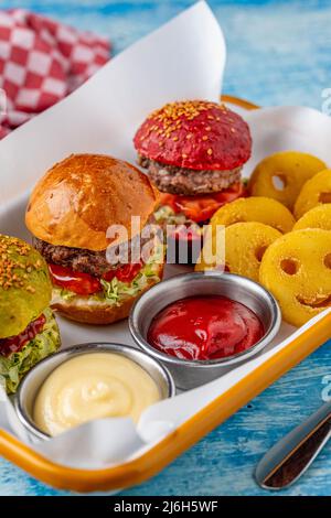 Drei Mini-Burger mit Huhn und Fleisch serviert mit pommes frites. Kindermenü Stockfoto