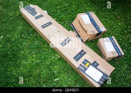 Paris, Frankreich - 29. April 2022: Mehrere Pakete klein, groß und lang mit Amazon Prime-Schriftzug im Garten grüner Rasen Stockfoto