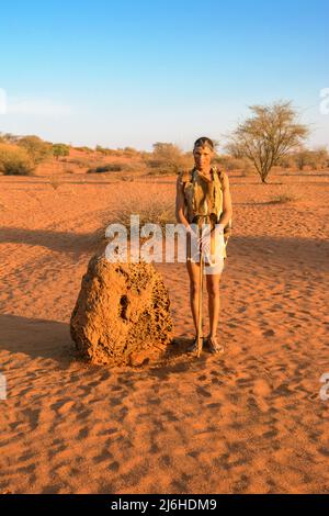 San (Saan) Buschmänner, indigene Jäger und Sammler, inspizieren Termitenhügel für Aardvark-Aktivitäten, Kalahari-Wüste, Namibia, Südwestafrika ... mehr Stockfoto