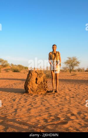 San (Saan) Buschmänner, indigene Jäger und Sammler, inspizieren Termitenhügel für Aardvark-Aktivitäten, Kalahari-Wüste, Namibia, Südwestafrika ... mehr Stockfoto