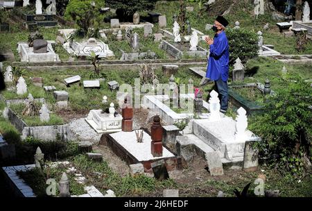 Muslime besuchen am ersten Tag des Eid Al-Fitr in Kuala Lumpur die Gräber ihrer Angehörigen auf einem Friedhof. Muslime auf der ganzen Welt feiern Eid al-Fitr und markieren damit das Ende des heiligen Fastenmonats Ramadan. (Foto von Wong Fok Loy / SOPA Images/Sipa USA) Stockfoto