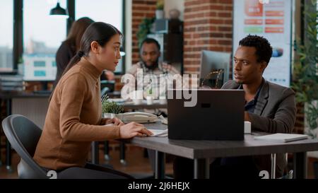 Mann und Frau arbeiten im Team, um Marketinganalysen für das Unternehmenswachstum zu erstellen. Büroangestellte haben Ideen gedanket und zusammenarbeiten, Finanzstatistiken auf Diagrammen betrachtet. Stockfoto