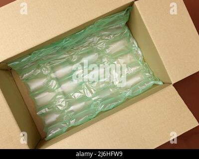 Polyethylen Air grüne Luftpolsterfolie in einem braunen Karton Draufsicht. Lieferkarton gefüllt mit Luftpolsterfolie aus Kunststoff. Verpackung von Produkten für die Lieferung, shi Stockfoto