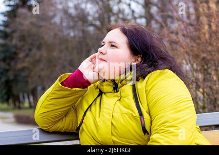 Glücklich attraktiv mollig übergewichtig kaukasische Frau lächelnd Porträt im Freien. Fröhliche hübsche Körper positive Person lachend während des Spaziergangs im Park. Stockfoto