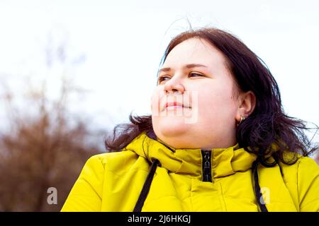 Glücklich attraktiv mollig übergewichtig kaukasische Frau lächelnd Porträt im Freien. Fröhliche hübsche Körper positive Person lachend während des Spaziergangs im Park. Stockfoto