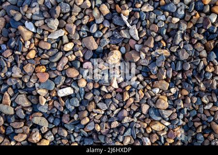 Hintergrund von kleinen Kieselsteinen und Steinen an der Küste oder im Garten Stockfoto