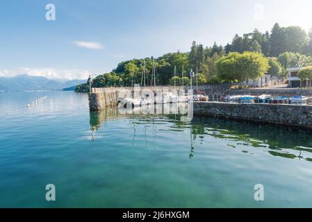 Typischer kleiner Hafen an einem großen See in Norditalien. Lago Maggiore am See der Stadt Ispra mit festgetäuten Booten. Sommerlandschaft Stockfoto