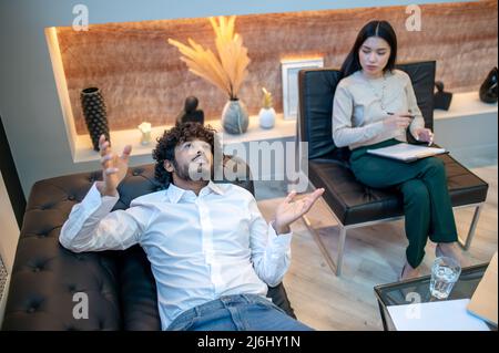 Junger männlicher Patient, der sich der Talkttherapie unterziehen muss Stockfoto