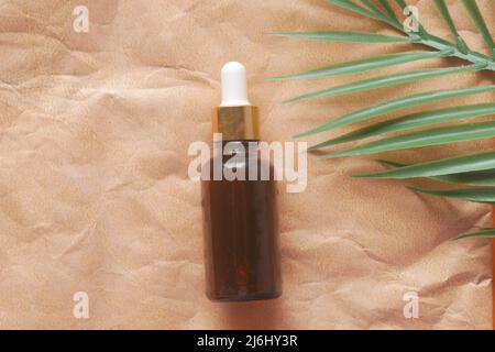 Ätherische Eukalyptus-Öle in einer Glasflasche und Blume auf dem Tisch Stockfoto