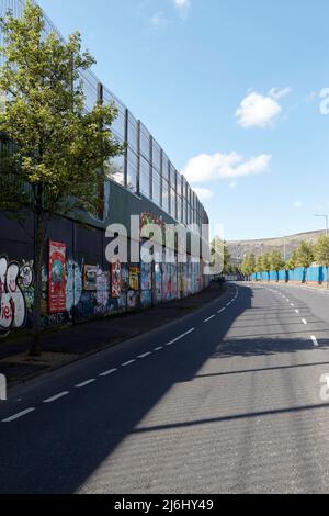 Die „Friedenslinie“, die die Grenze zwischen dem Gebiet der Catholic Falls Road (hinter der Mauer) und dem Gebiet der Protestant Shankill Road, Cupar Way, WestBelfast, N, trennt Stockfoto