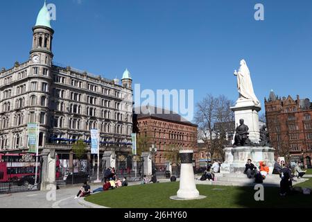 Die Menschen genießen die Frühlingssonne auf dem Gelände des Belfast City Hall, Nordirland, 20.. April 2022. Stockfoto