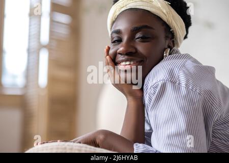 afroamerikanische Frau, die auf dem Bett lag und verträumt aussahnte Stockfoto
