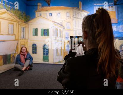 London Shoreditch, Großbritannien. 30 April 2022. Die Familie fotografiert mit dem Mobiltelefon im Hintergrund der Stadt Arles bei Van Gogh die Ausstellung „Immersive Experience“ Stockfoto