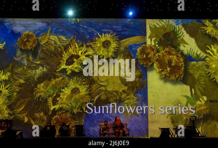 London, Großbritannien. 30. April 2022. Zuschauer beobachten Sunflowers-Serie bei Van Gogh The Immersive Experience mit illustrierten Licht- und Klanggeschichten. Stockfoto