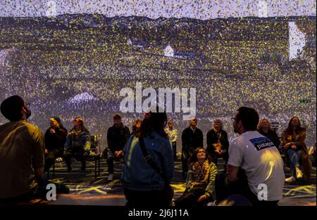 London, Großbritannien. 30 April 2022. Zuschauer beobachten die Ernte bei Van Gogh das immersive Erlebnis mit illustrierten Licht- und Tonprojektionen. Stockfoto