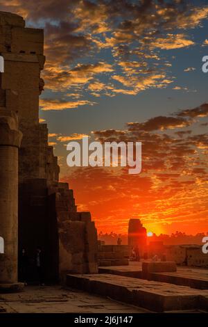 Ein entfernter Fotograf an den Wänden des verlassenen kom ombo-Tempels in ägypten nimmt eine wunderschöne Sonnenuntergangsszene auf Stockfoto