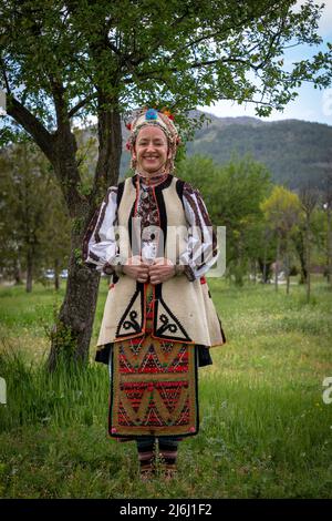 Seslavtsi, Bulgarien, 30. April 2022: Eine Frau in traditioneller Tracht bei einem Folklorefestival in Bulgarien. Authentisches 100 Jahre altes Kostüm Fr. Stockfoto