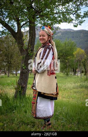 Seslavtsi, Bulgarien, 30. April 2022: Eine Frau in traditioneller Tracht bei einem Folklorefestival in Bulgarien. Authentisches 100 Jahre altes Kostüm Fr. Stockfoto