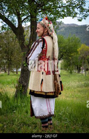 Seslavtsi, Bulgarien, 30. April 2022: Eine Frau in traditioneller Tracht bei einem Folklorefestival in Bulgarien. Authentisches 100 Jahre altes Kostüm Fr. Stockfoto