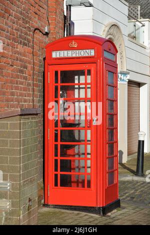 Traditionelle hellrote britische Telefonbox Stockfoto