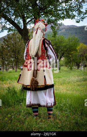 Seslavtsi, Bulgarien, 30. April 2022: Eine Frau in traditioneller Tracht bei einem Folklorefestival in Bulgarien. Authentisches 100 Jahre altes Kostüm Fr. Stockfoto