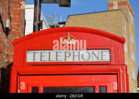 Detail des Kronenlogos an der Oberseite einer traditionellen roten britischen Telefondose Stockfoto