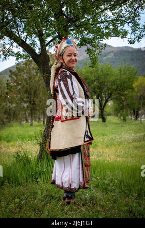 Seslavtsi, Bulgarien, 30. April 2022: Eine Frau in traditioneller Tracht bei einem Folklorefestival in Bulgarien. Authentisches 100 Jahre altes Kostüm Fr. Stockfoto