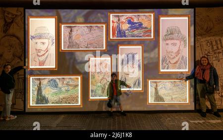 London, Großbritannien. 30. April 2022. Eltern mit Kindern präsentieren gescannte Abzüge zur Bildschirmanzeige in der Van Gogh Ausstellung „The Immersive Experience“. Stockfoto
