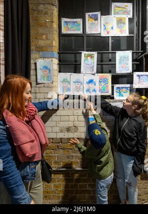 London Shoreditch, Großbritannien. 30. April 2022. Eltern mit Kindern malen einen Druck bei Van Gogh die Immersive Experience Ausstellung. Stockfoto