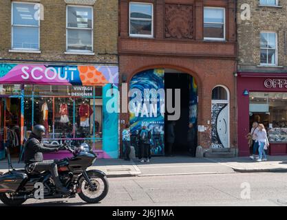London Shoreditch, Großbritannien. 30. April 2022. Blick auf die Straße vor dem Eingangstor mit Personen, die Van Gogh die Ausstellung „Immersive Experience“ betreten. Stockfoto