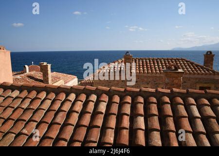 Landschaft mit Panoramablick auf die Häuser im venezianischen Stil mit Ziegeldächern in der befestigten Stadt Monemvasia in Lakonien, Peloponnes, Griechenland. Stockfoto