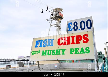 Brighton UK 2. May 2022 - traditionelle Fisch- und Chips-Gerichte am Meer auf Bankfeiertag, während Besucher des Brighton Zip Wire eine Mischung aus Sonnenschein und Wolken genießen : Credit Simon Dack / Alamy Live News Stockfoto