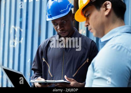 Professioneller Ingenieur und Geschäftsmann überprüft und inspiziert Container in internationaler Fracht im Logistikhafen. Industrie, Transport, warehou Stockfoto