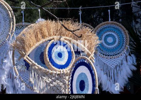 Böse Augen makrame Wanddekoration auf Souvenirmarkt. Augenförmiges Symbol. Nazar, glaubte, vor schlechten Augen zu schützen. Handgemachte verschiedene Talismane. Stockfoto