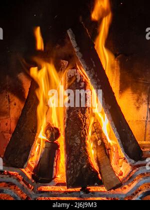 Schöne brüllende Flammen Holzfeuer im Kamin brennen. Ein Feuerholz brennt warm. Moderner Kamin als Möbel, Heimtextilien. Romantisch Stockfoto