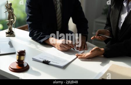 Rechtsberater präsentiert auf dem Client einen unterzeichneten Vertrag mit Hammer und rechtlichen Gesetz. Justiz und Rechtsanwalt Konzept. Stockfoto