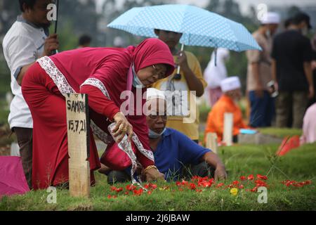 Eine Reihe von Bewohnern pilgern zu den Gräbern von Verwandten während der Feier des Eid Al-Fitr 1443 Hijri, am besonderen Grab für die Opfer von Covid-19, Rorotan Public Cemetery, Cilincing, Jakarta, Indonesien. Die diesjährige Eid al-Fitr-Feier wurde von einer Reihe von Muslimen genutzt, um Wallfahrten zu machen und für ihre Familien zu beten, die gemäß dem Covid-19-Protokoll begraben wurden. (Foto von Kuncoro Widyo Rumpoko/Pacific Press) Stockfoto